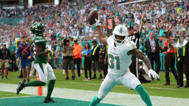 Miami Dolphins running back Raheem Mostert (31) spikes the ball after scoring a touchdown past New York Jets safety Tony Adams (22) during the first half of an NFL game at Hard Rock Stadium in Miami Gardens, Dec. 17, 2023.